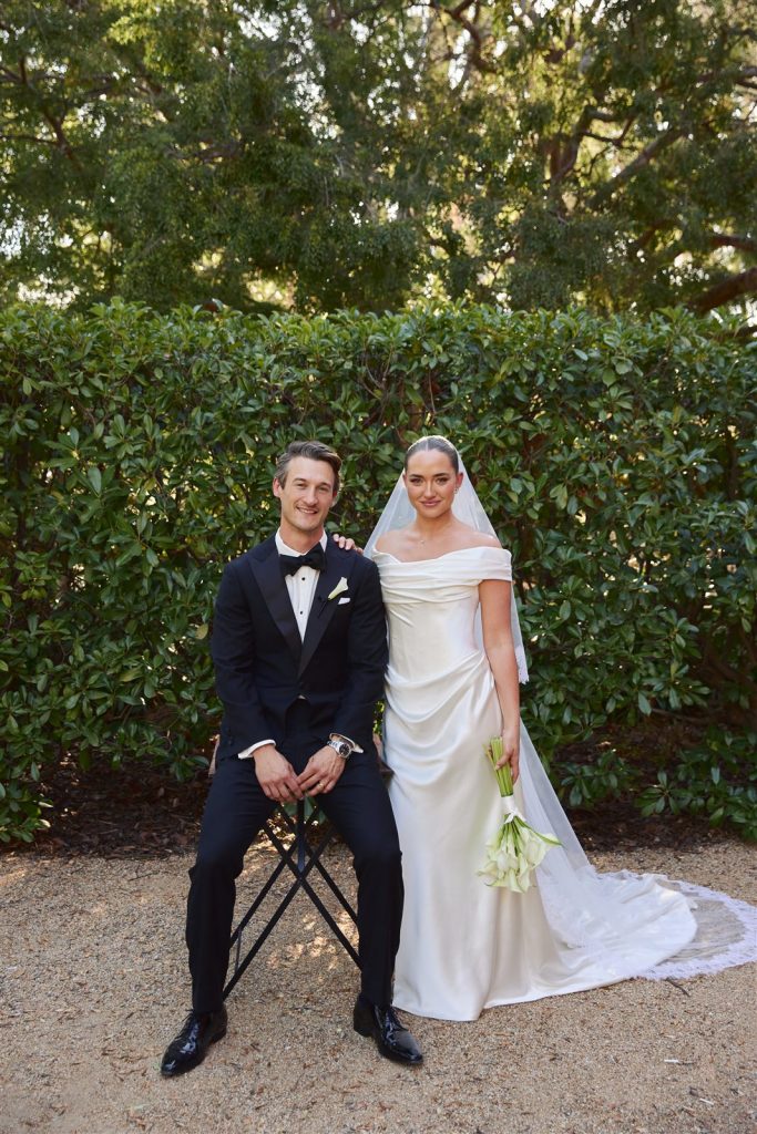 Bride in a d’Italia custom off-the-shoulder satin wedding gown with her groom